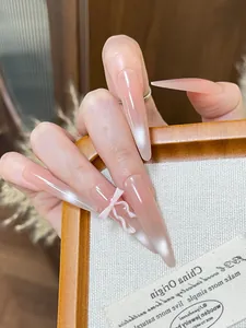 Long stiletto press-on nails with nude pink gradient, cat eye finish and 3D bow detail