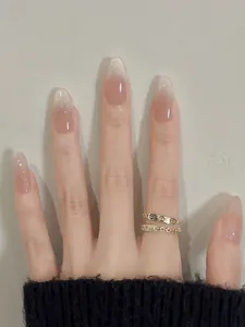 Detailed view of press-on nails with nude pink ombre gradient and glossy almond shape finish