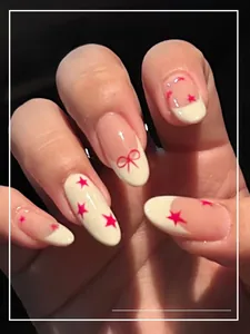 Detail of pink bow and star patterns on medium oval press-on nails for a French look