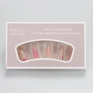 Detail of pink almond-shaped press-on nails with floral patterns in box packaging