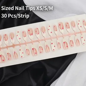 Pink French almond press-on nails with red stars and bows on black silk background