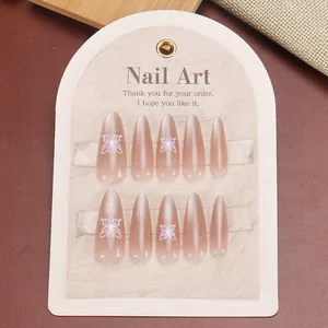 Long almond press-on nails in nude pink with pearl finish and white butterfly designs