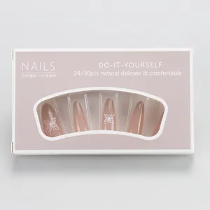 Detail of nude pink long almond press-on nails with white butterfly patterns in packaging
