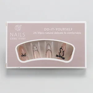 Close-up of long almond press-on nails with black lace patterns and pearl bows