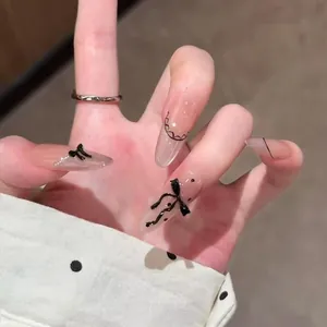 Long almond press-on nails with black lace patterns, pearls, and 3D bow accents