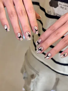 Short square press-on nails with silver glitter, black stars and lightning patterns