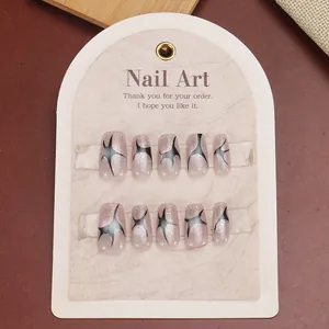 Short coffin punk press-on nails in pale pink shimmer with black starburst patterns
