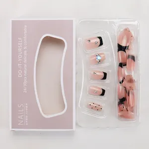 Detail of luxury press-on nail kit featuring black French tips, pink glitter, and rhinestones