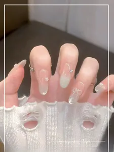 Detail of pink gradient press-on nails with pearl, rhinestone, and 3D bow accents