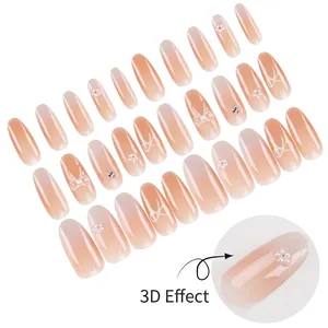 Handmade almond press-on nails with 3D pearl flowers, bows, and crystals in nude gradient