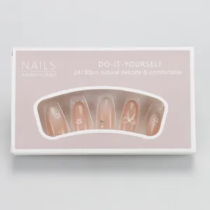 Macro view of nude pink gradient press-on nails with pearl flowers and bow details