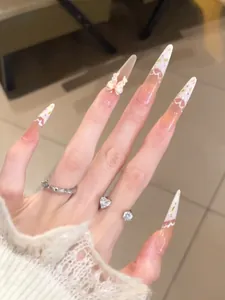 Detailed view of handmade almond press-on nails with 3D bows and lace floral design