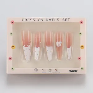 Detail of pink gradient French fake nails with lace bow and colorful polka dot pattern