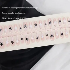 Handmade almond press-on nails with pink gradient, black stars and 3D pearls