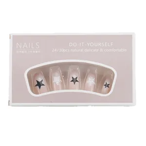 Pink gradient press-on nails with black and pearl star charms in a window box package