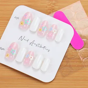 Kit faux ongles courts ovales avec motifs floraux roses et fini blanc brillant