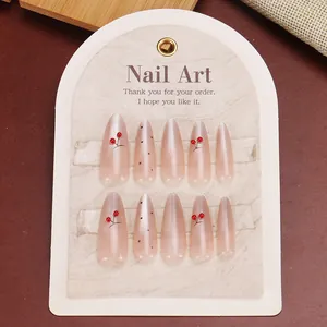 Pink cat eye press-on nails with red cherry designs in long almond shape