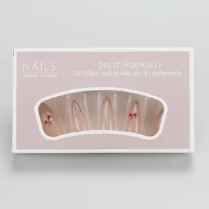 Detail of nude pink almond press-on nails with 3D cherry patterns and polka dot accents