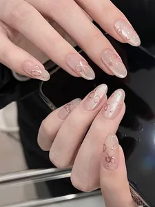Detail von mandelförmigen Nägeln mit rosa Basis, 3D Roségold-Schleifen und Herzen