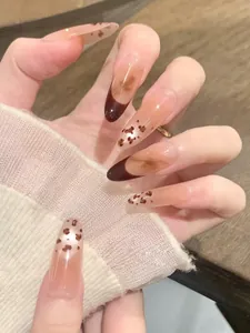 Détails de faux ongles amande avec motif léopard et pointes françaises marron