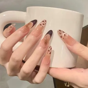 Faux ongles amande longs avec dégradé nude, french marron et motifs de taches ambrées