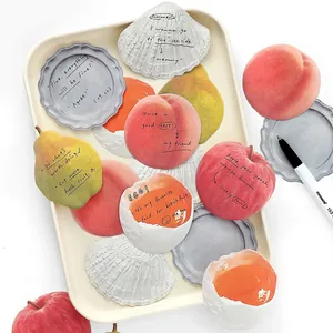 Cute fruit shaped sticky notes in peach and apple designs on a white tray