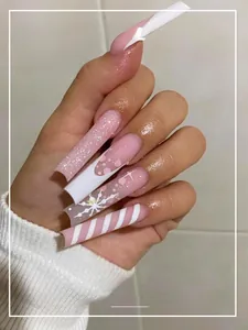 Detailed view of pink Christmas press-on nails with glitter snowflakes and stripes