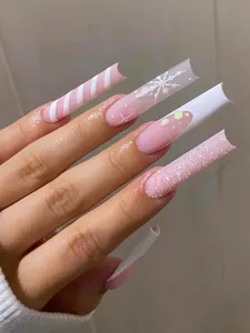 Detailed view of extra long Christmas nails with pink glitter and snowflake patterns