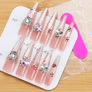 Detail of luxury press-on nails with pink glitter gradient and silver rhinestones