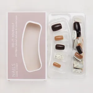 Short press-on nails in deep brown and ink splatter white displayed in a box