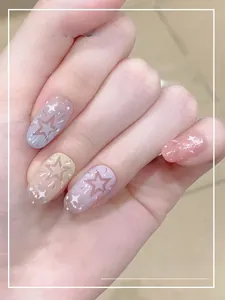 Close-up of pastel macaron gradient press-on nails with hollow star and glitter patterns