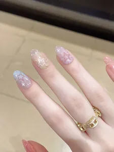 Macro shot of macaron gradient press-on nails with star glitter and gold H-link ring