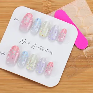 Short macaron gradient press-on nails set with glitter star patterns and tools on tray