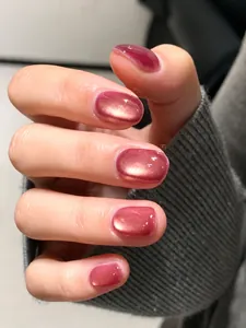 Makroaufnahme von pinken Cat-Eye-Nägeln zum Aufkleben mit glänzendem Spiegeleffekt