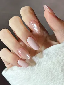 Detailed close-up of pearlized nude pink press-on nails in long almond shape