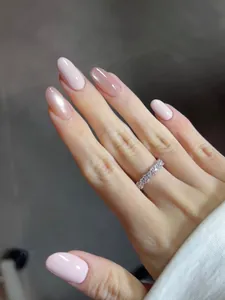 Detailed view of pink gradient manicure paired with a sparkling eternity band ring