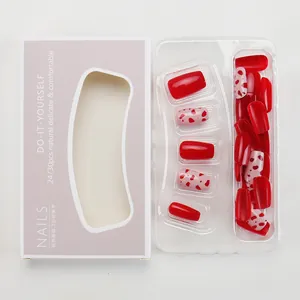 Short press-on nails set with red heart patterns in a professional display box
