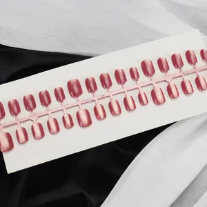 Makroaufnahme von 30 handgefertigten rosa Katzenaugen-Nägeln auf Karte mit Seide