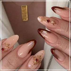 Almond press-on nails in burgundy and nude pink with gold lines and rhinestones