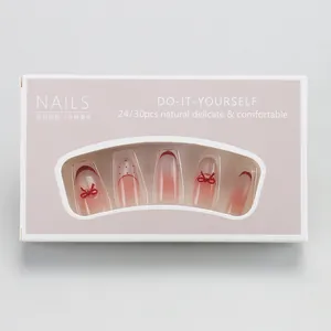 Pink gradient press-on nails with 3D red bows in elegant DIY window packaging