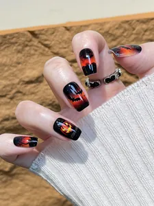 Halloween press-on nails with orange gradient pumpkin and bat motifs on black base