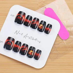 Macro detail of Halloween gradient nails with pumpkin and bat patterns on wood