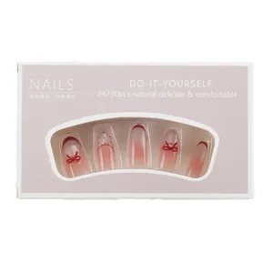 Press-on nail set in nude pink with red bows and gradients on long coffin nails