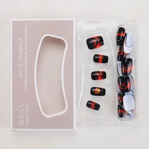 Detail of Halloween press-on nails featuring orange gradient with pumpkin and bat patterns