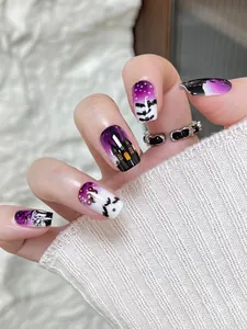 Detailed close-up of Halloween press-on nails with purple bat and castle motifs