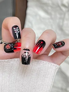 Detalle de uñas góticas de Halloween con diseños de rosas rojas y murciélagos