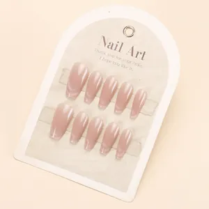 Handmade cat eye press-on nails set in nude pink coffin shape on a display card