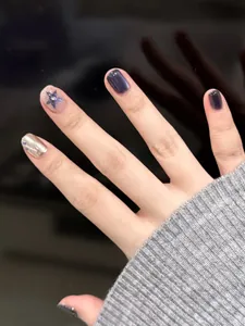 Macro shot of dark purple glitter and silver star short press-on nails for women