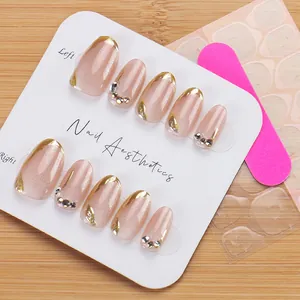Detail of short oval press-on nails set with nude glitter finish and rhinestone accents