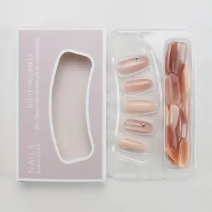 Detailed view of nude pink press-on nails with rhinestones and shimmer in retail packaging